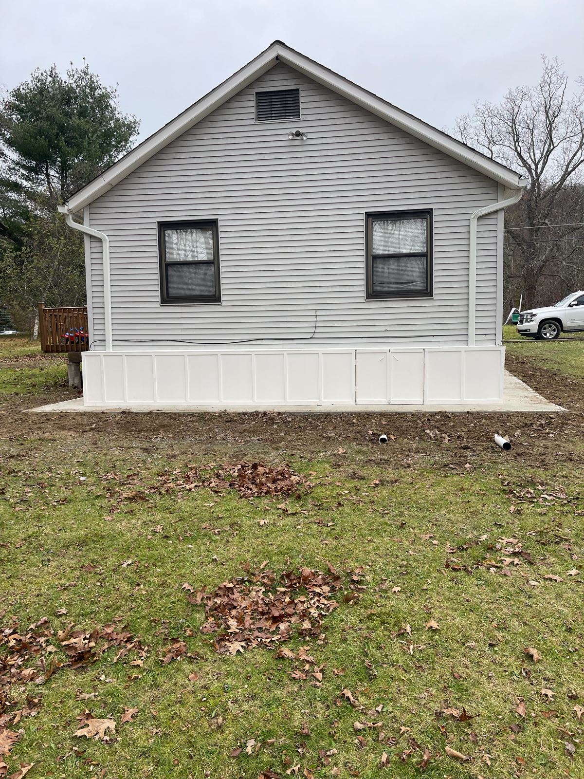 House with new white board-and-batten skirting around the base